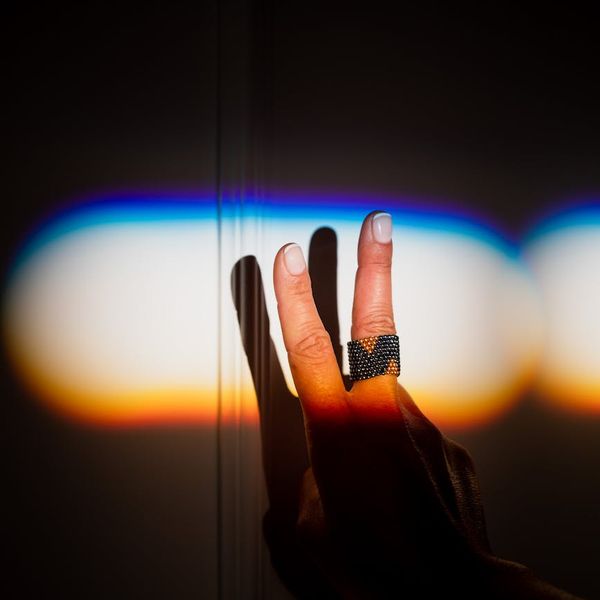 Abstract shadow of a person stretching against a dark wall.